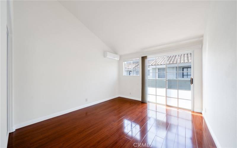 Guest bedroom 2, with shared balcony and AC wall unit.