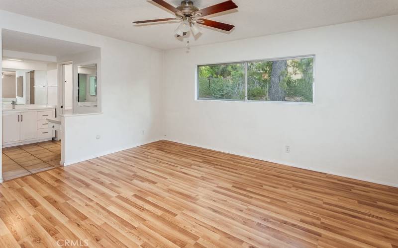 The primary bedroom is drenched in natural light from glistening windows and is enriched with dual closets with mirrored wardrobe doors and gleaming wood laminate floors.