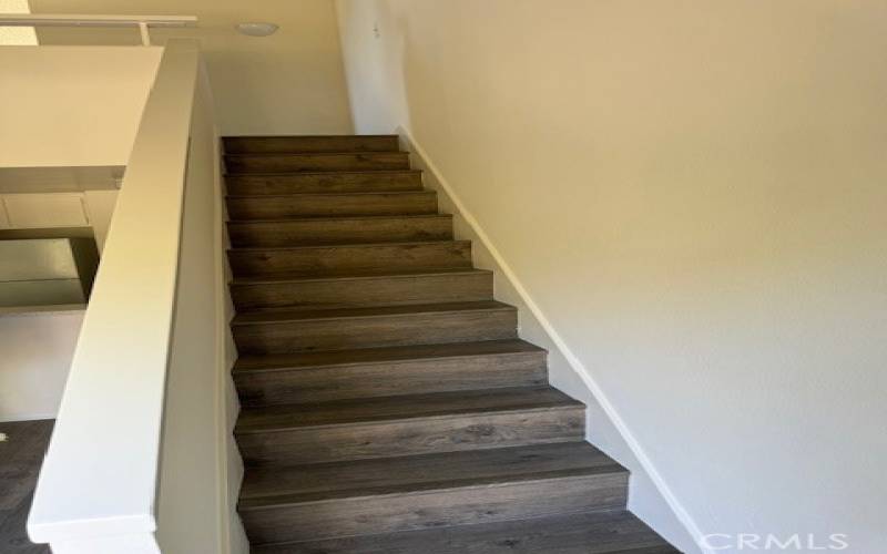 STAIRCASE LEADING TO LOFT  HAS WOOD LAMINATE ON STAIRS