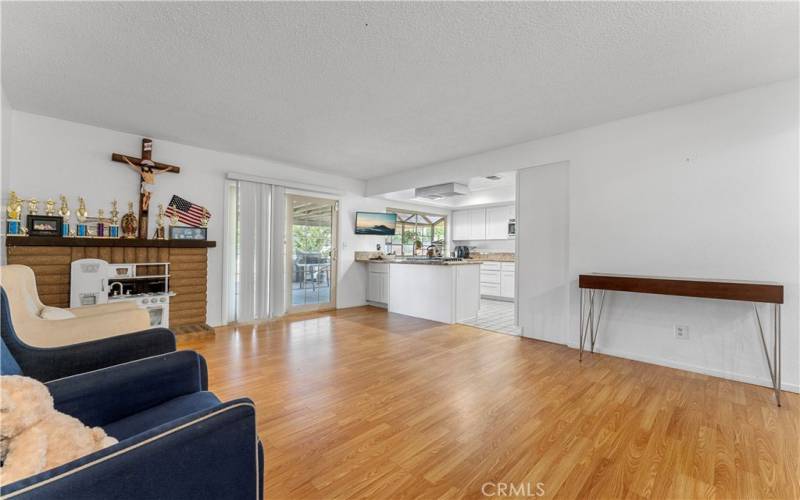 Family room opens up to the updated kitchen. Sliders to the oversized covered patio. Fireplace in the corner of the image (left)