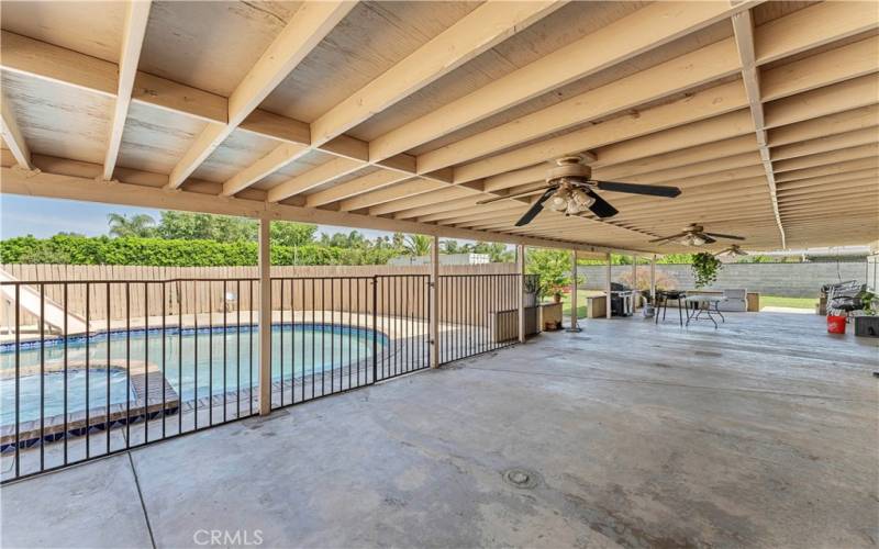 Oversized covered patio with fenced pool.