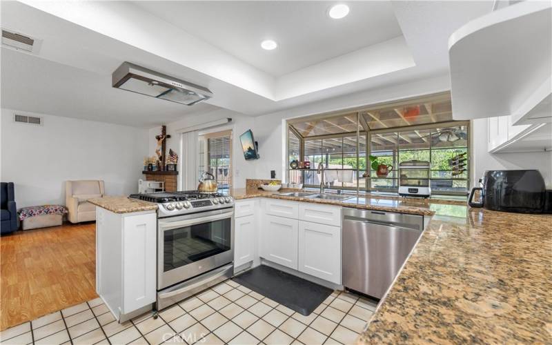 Shaker cabinets and granite counters with a large garden window overlooking the backyard.