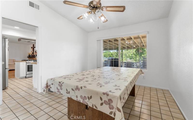 Formal dining room with ceiling fan and tiled flooring. Throughway to the updated kitchen and family room.