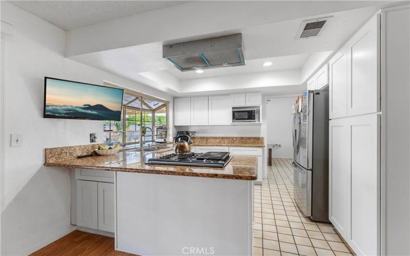 Updated kitchen includes shaker cabinets and granite counters.