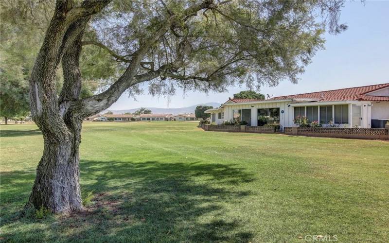 View of dining room at right from shade of tree on golf course.