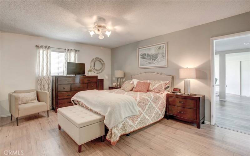 Main bedroom with wood flooring has access to bonus room.