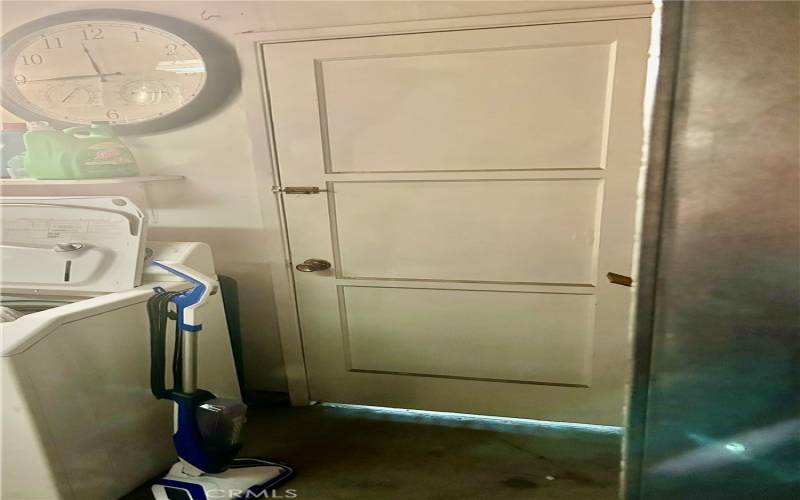 Laundry area inside garage HAS door leading into storage shed.