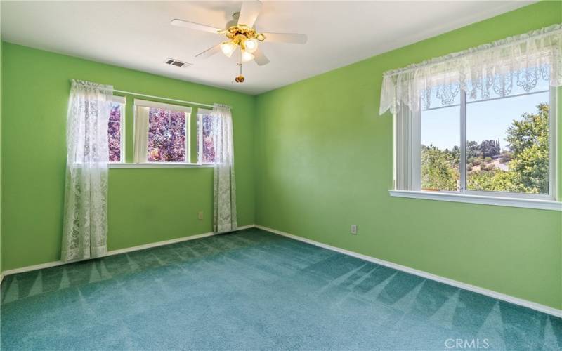 Spacious bedroom 3 is carpeted with a ceiling fan.