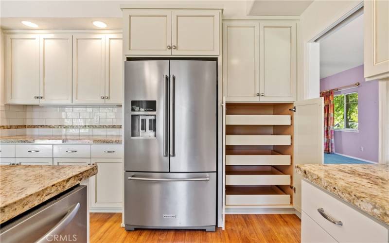 With ample storage, there is a prep counter or coffee nook/beverage area available in this great kitchen. Check out the pull-out drawers for all of your pantry needs. Lovely stainless-steel refrigerator stays!