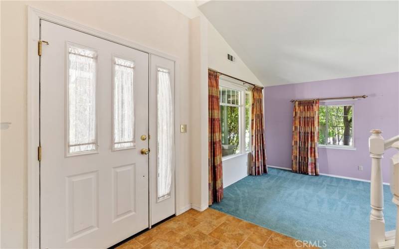 This step-down living room has many windows that allow some great lighting in. Carpeted, with high vaulted ceilings, this room waves you in from the entry way.