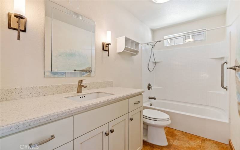 Strategically located near bedrooms 2 and 3 is a full bathroom. This bath enjoys lovely cabinetry and hard surface countertops with sconce lighting.