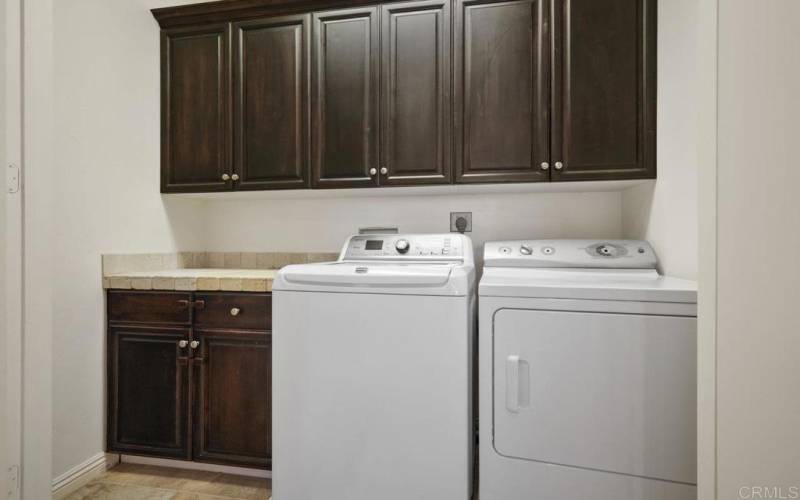 Upstairs Laundry with storage and counter for folding. Conveniently located near all bedrooms.