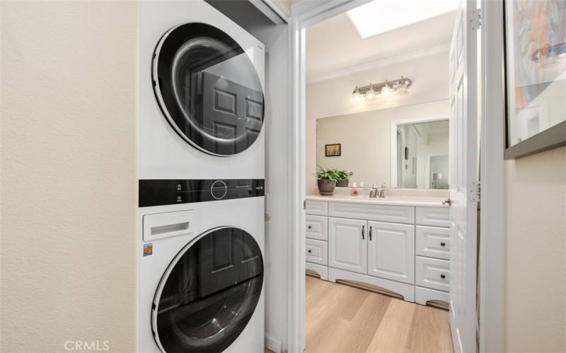 Indoor laundry in hallway includes stack washer/dryer