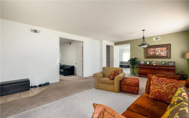 Another view of living room and double doors to the office/den.