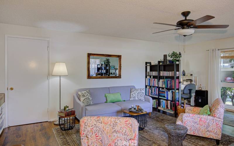 The living room is so large, the owner has divided it to make a nice desk area just behind the book dividers.