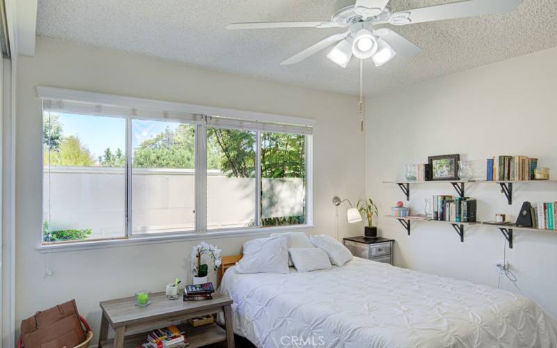 Pretty bedroom is spacious with a ceiling fan to keep those coastal breezes moving.