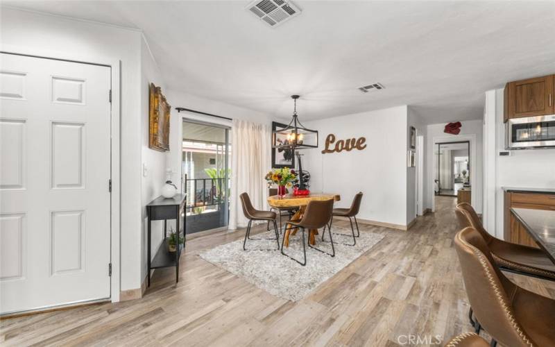 Off kitchen dining area with sliding glass door leading to covered front porch deck.