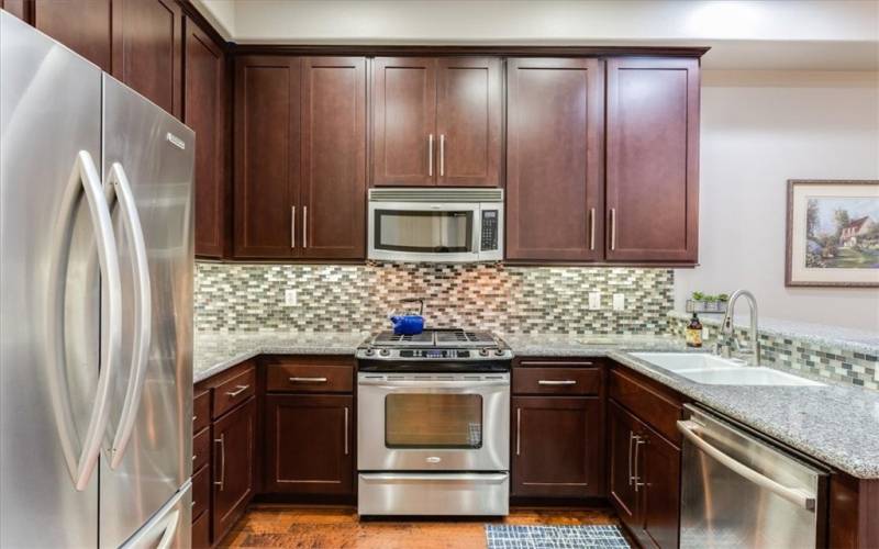 Kitchen with Glass Tiles Backsplash, Stainless Steel Microwave and Oven with Cook top