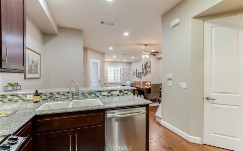 Another View of Kitchen with Beautiful Cabinetry, Granite Counter tops, Dual Sinks and Stainless Steel Dishwasher.  Pantry door is on the Right.