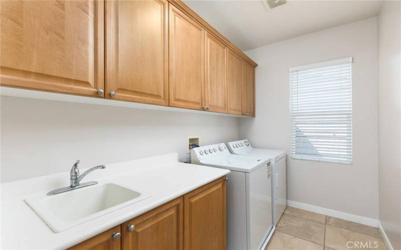 Upstairs laundry with sink and LOTS of cabinets!  Yes, washer and dryer stay!