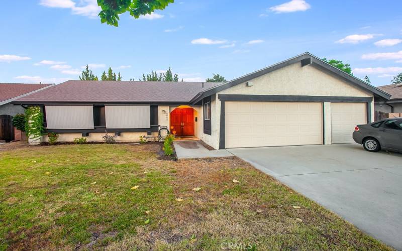 The front yard with its sprawling lawn, colorful flowerbeds towering shade tree and covered entry enhance its eye-catching curb appeal