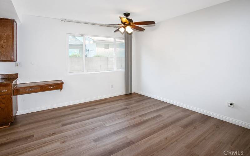 Convenient breakfast nook with glistening window, lighted ceiling fan and wood laminate floors.