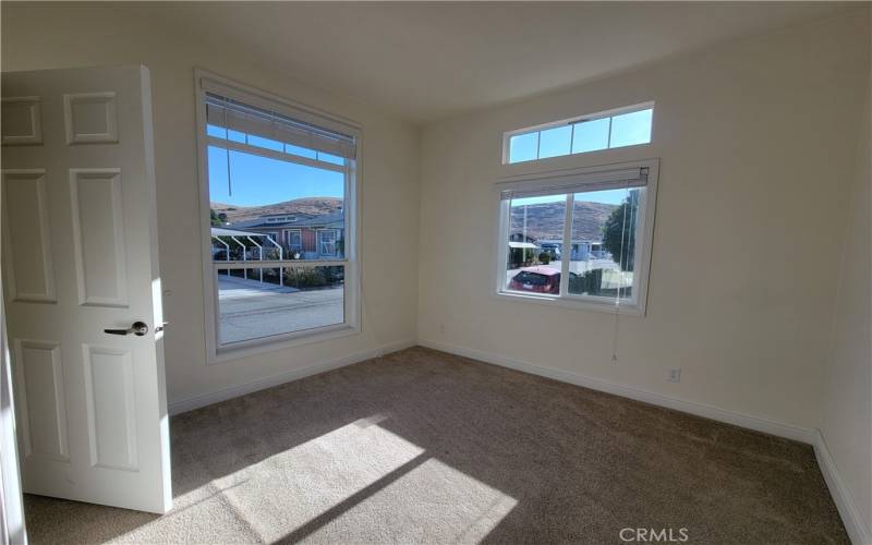 The bright second bedroom has lovely views of the Irish Hills.