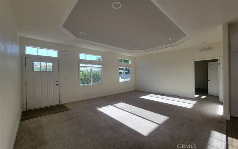 The spacious bright livingroom with ceiling features and crown molding opens to the large kitchen.