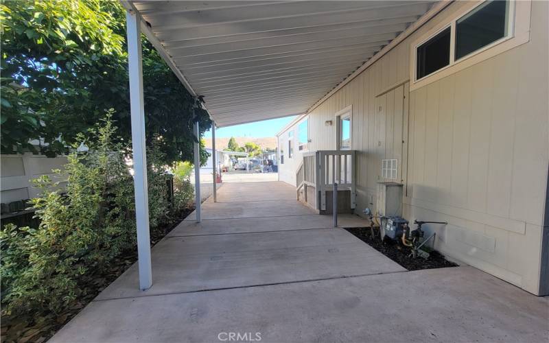 The covered carport can accommodate 3 cars tandem.