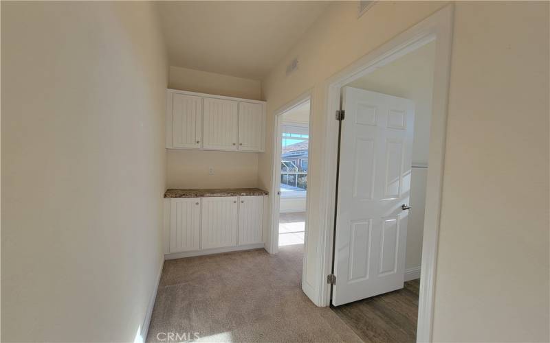 Hallway to the guest bath and bedroom with linen storage to boot!