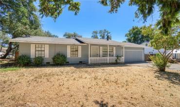 Front of home with large front yard on corner lot.