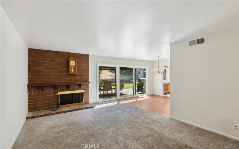 Spacious entry into home showcases the brick fireplace and slider to backyard