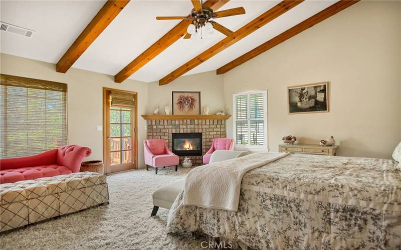 Beamed Ceiling and Cozy Fireplace in this Primary Bedroom