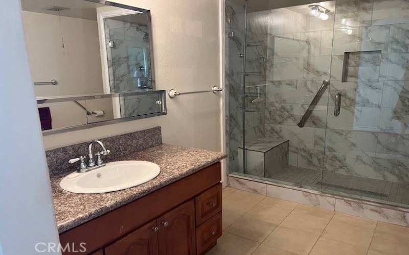 Two vanities with granite countertops and wood cabinetry.