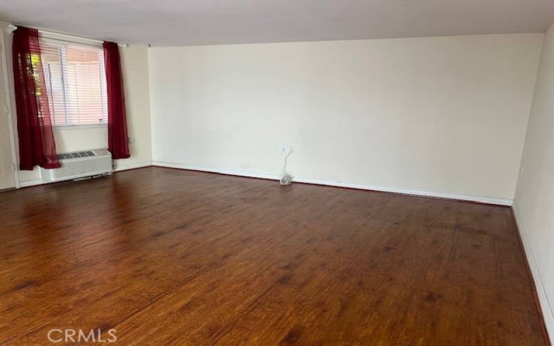 Spacious living room with gleaming wood laminate floors.