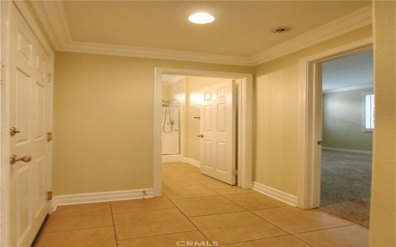 Hallway leading to garage, guest bathroom, and downstairs guest bedroom.