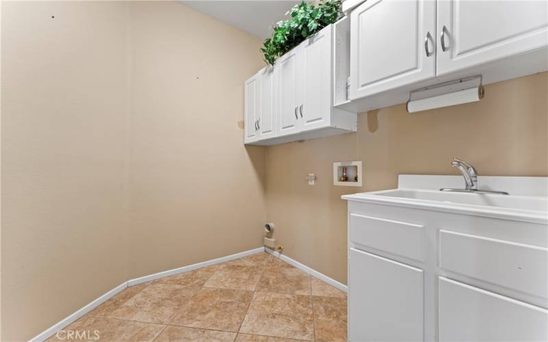 Indoor Laundry Room with Overhead Cabinets and Sink