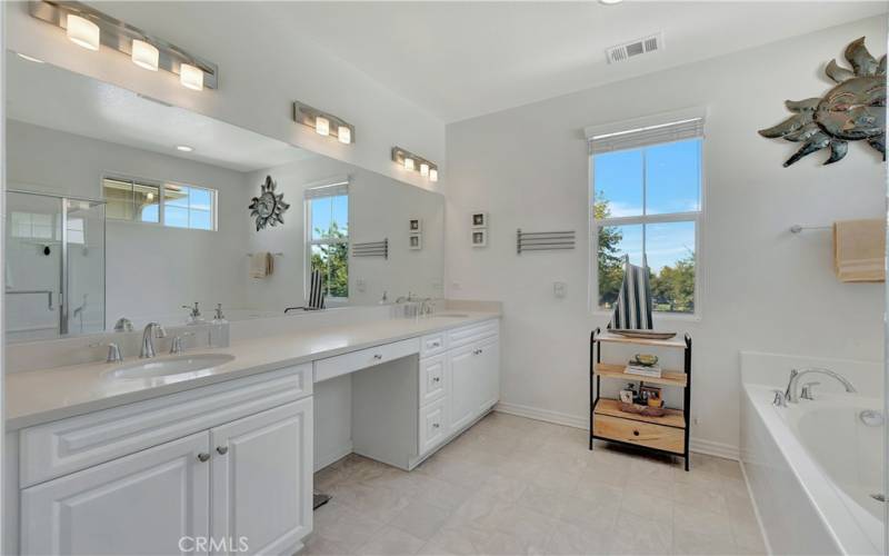 Primary en-suite bathroom w/ two sinks plus a vanity area