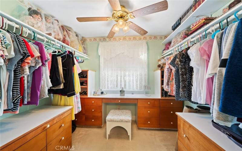 Walk in closet with built in drawers and makeup counter