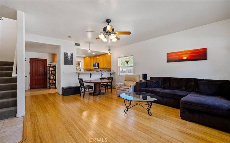 Living area with bamboo flooring open to kitchen