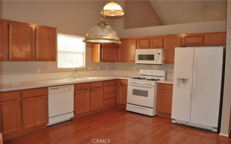 KITCHEN WITH WOOD FLOORS, QUARTZ COUNTER TOPS AND INCLUDED APPLIANCES