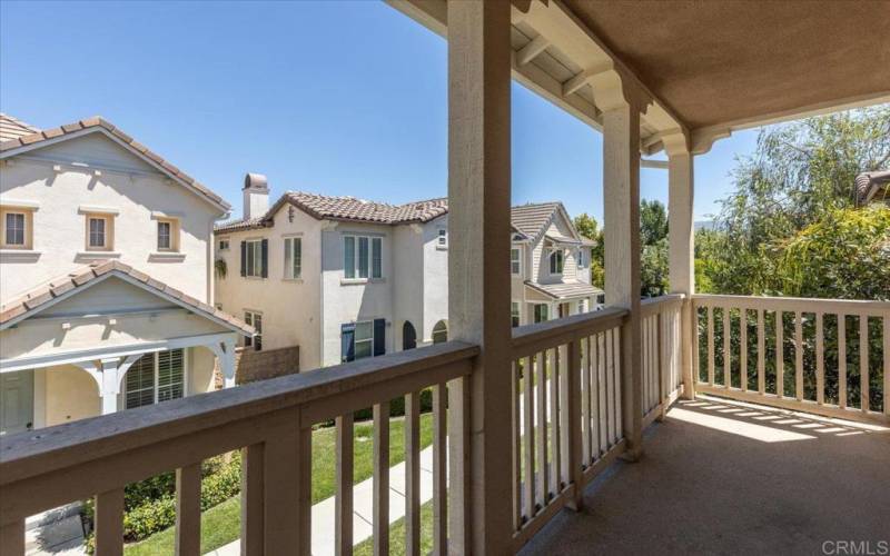 Balcony faces the grassy front walkway, charming neighbors' homes and pretty flowering trees.