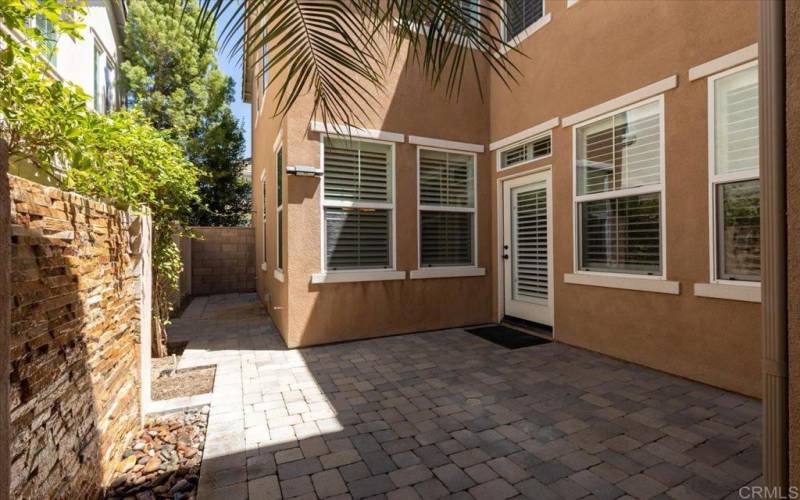 The patio is has a cobblestone hardscape and is accessed between the living & dining rooms