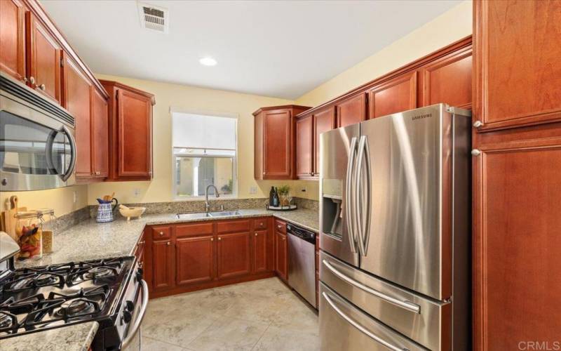 Kitchen with stainless appliances and refrigerator that all convey