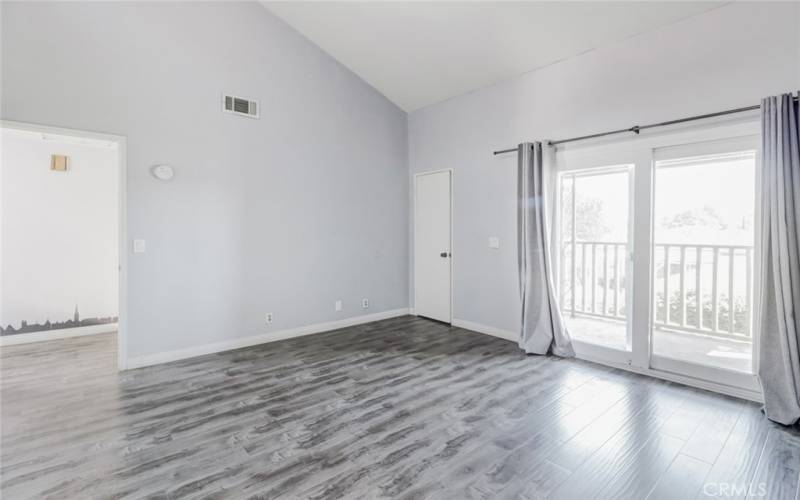 Primary bedroom, hallway door, walk-in closet, slider door to private balcony.