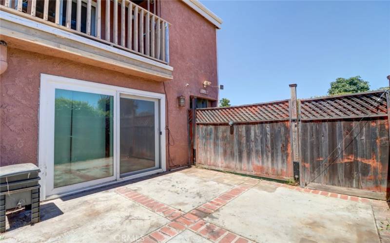 Front patio with wooden side door in the fence.