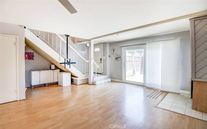 Living room sliders open to fenced patio.