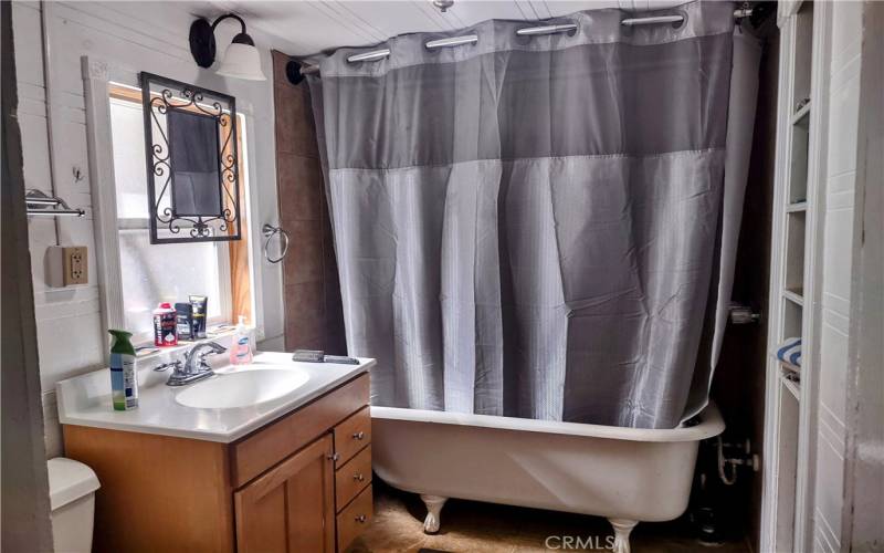 bathroom with tiled wall and clawfoot tub