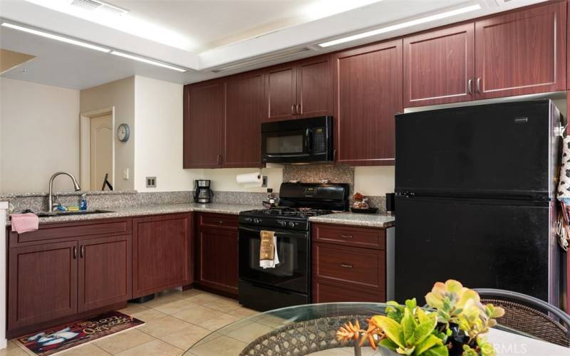 Kitchen with dark wood cabinetry and gas stove