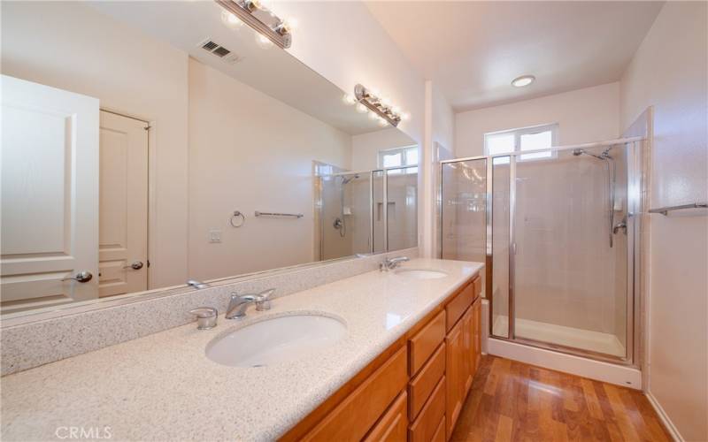 Elegant master bath with tall dual sink vanity, big shower and privacy door commode.